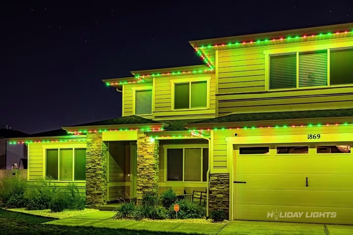 Permanent roofline lights installed along the full eaves of a Maine home